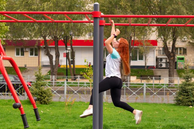 Woman climbing monkey bars in outdoor