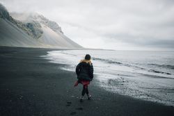Woman walking on rocky coast on a winter’s day