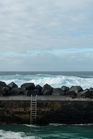 Sea waving near stone pier
