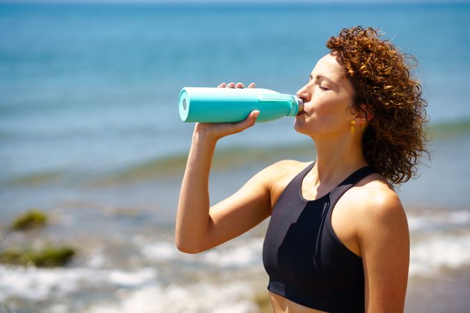 Sportswoman drinking water from bottle