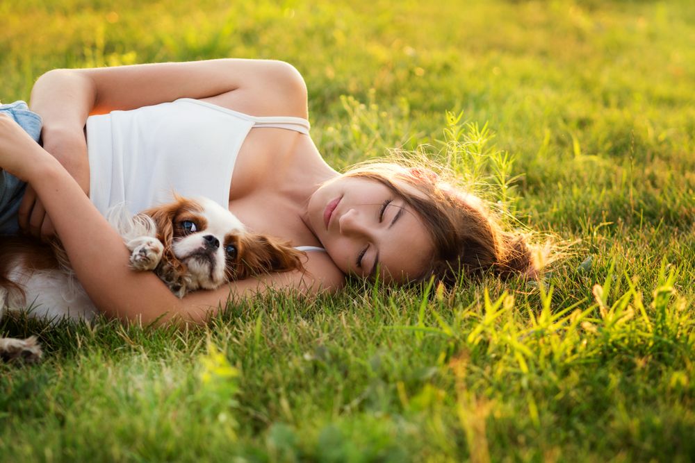Teen girl happily hugs the dog