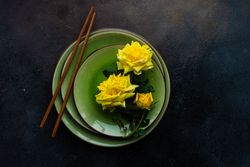 Top view of green table setting with yellow roses