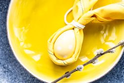 Easter holiday table setting with yellow egg decoration in bowls