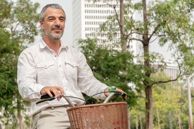 Mature grey haired man cycling in park