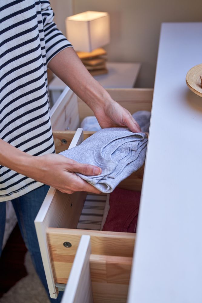 Crop woman taking cloth out of closet