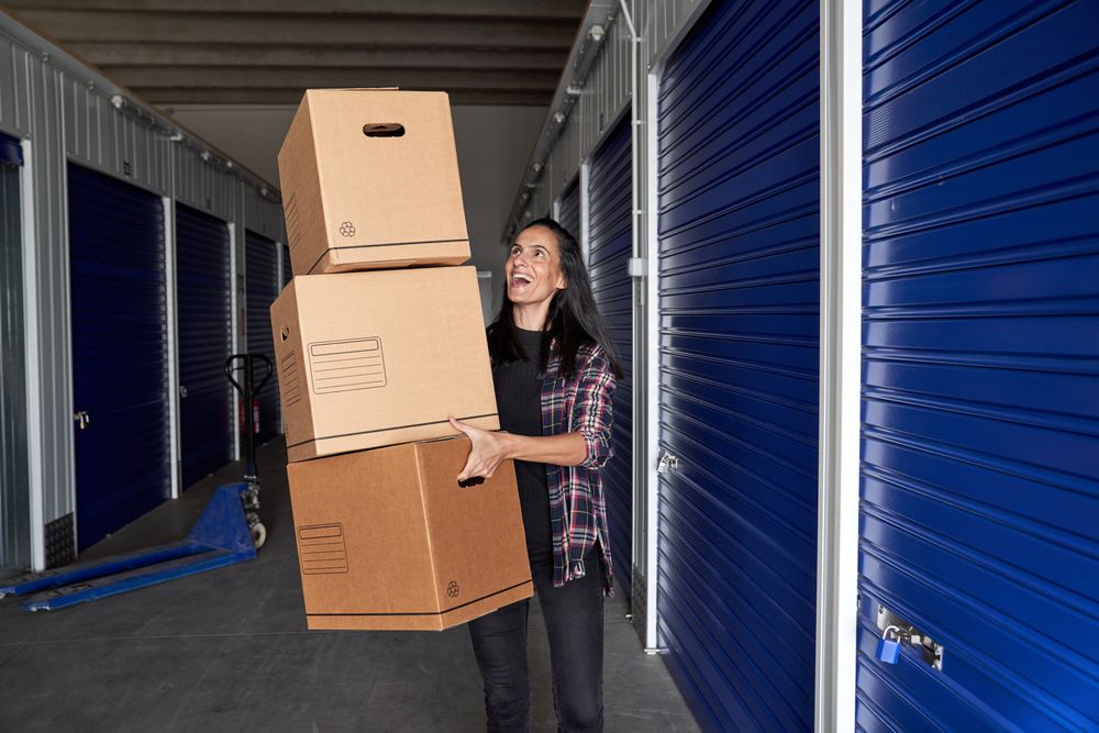 Cheerful woman carrying carton boxes