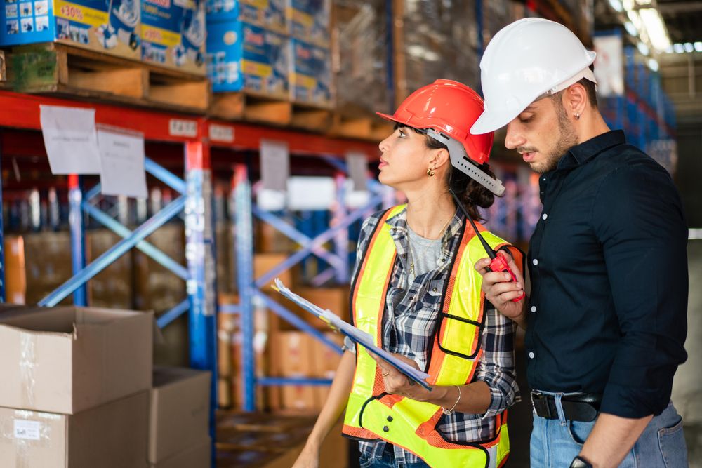 Two logistics workers checking stock distribution before shipping