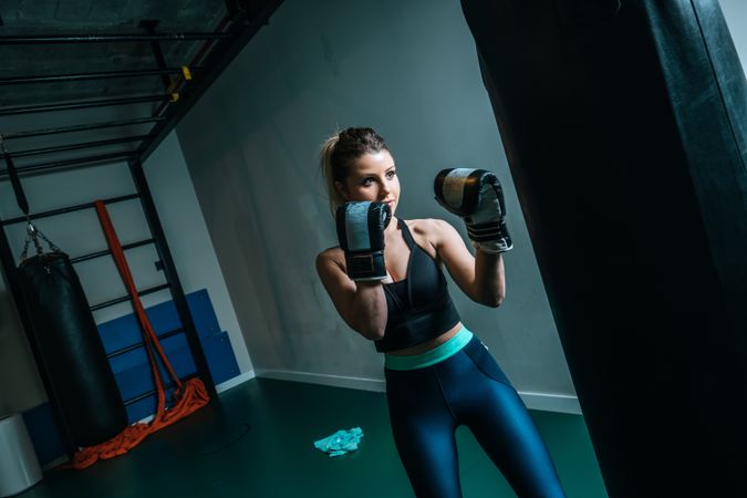 Woman training in gym with punching bag