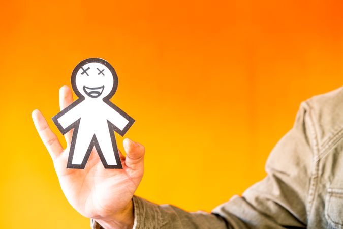 Smiling man holding funny paper toy