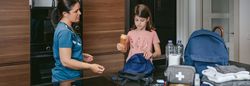 Mother explaining to her daughter how to prepare an emergency ba