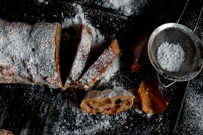 Pieces of Stollen near sieve and autumn leaves