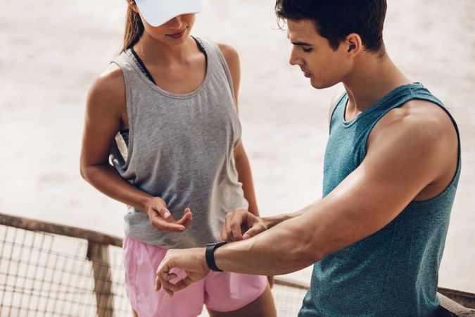 Fitness couple checking performance on a smart watch