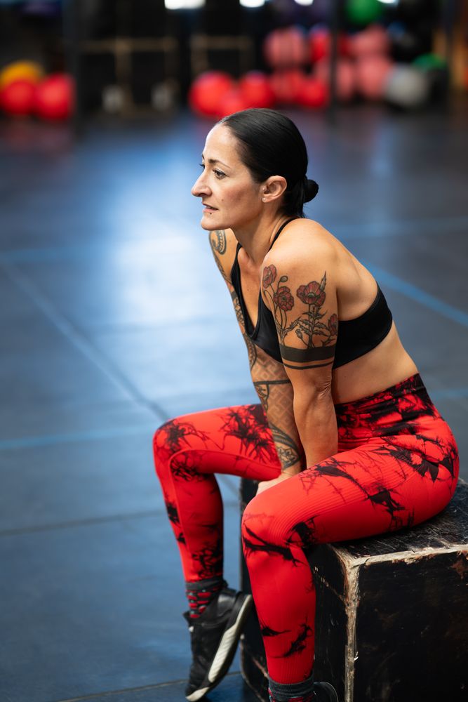 Fit woman sitting on a box resting after training