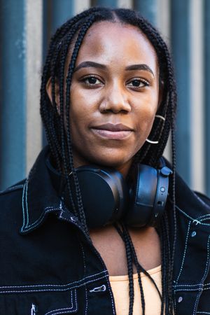 Black woman leaning on wall near park