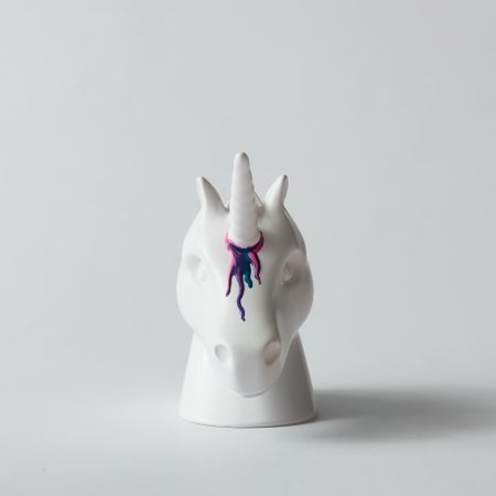 Painted unicorn head with colorful paint dripping on bright background