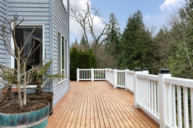 Freshly stain large home walk out cedar wood deck patio during early spring