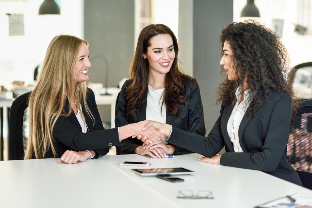 Female business leaders shaking hands in office after a successful meeting