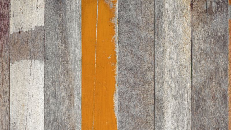 Weathered wooden wall with colorful painted planks and rustic texture