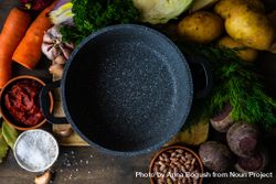 Top view of fresh ingredients for borscht soup surrounding pan 5oDqYG