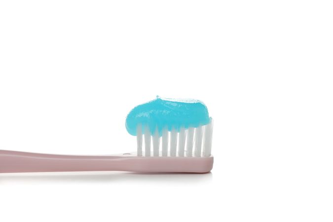 Toothbrush with toothpaste isolated on light background