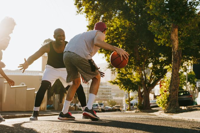 Four men playing basketball on street