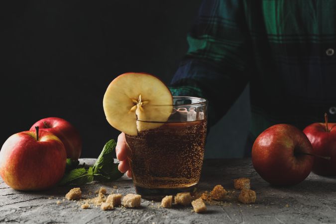 Woman hold glass of cider. Composition with cider on gray table