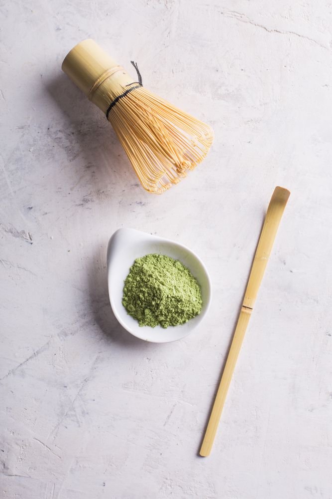 Green matcha tea powder and bamboo whisk