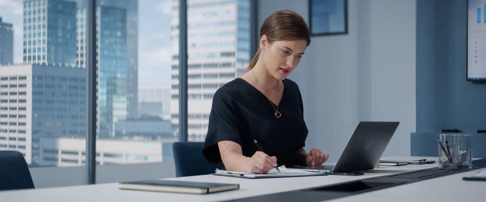 Successful Businesswoman Working on Laptop Computer in Big City Corner Office.