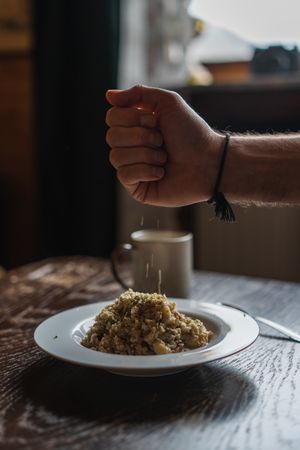 Man hand sprinkling food