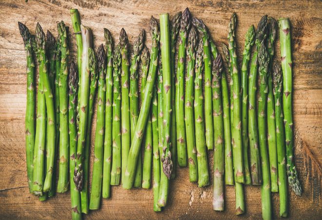 Asparagus lined up on wooden board