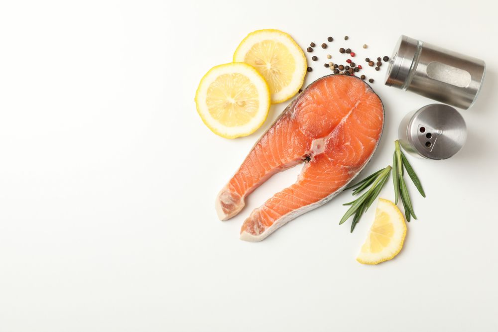 Composition with salmon meat and spices on light background, top view