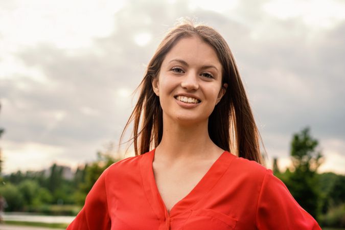 Smiling young woman in red outdoors
