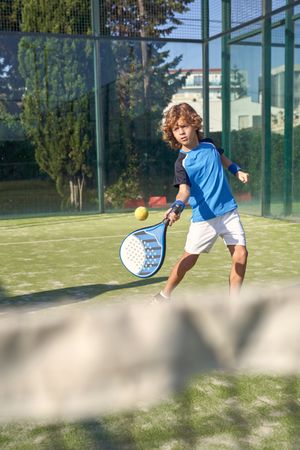 Boy hitting ball with racket