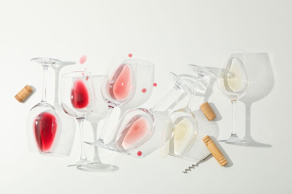 Flat lay composition. Corkscrew, glasses with different wine on blank background