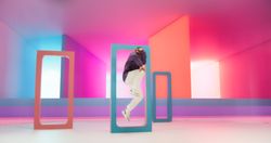Young And Athletic White B-Boy Breakdancing To Break Beats in a Colorful Abstract Neon Lit Studio. Energetic Fashionable Male Dancer Talentedly Performing His Choreography On Multicolored Set.