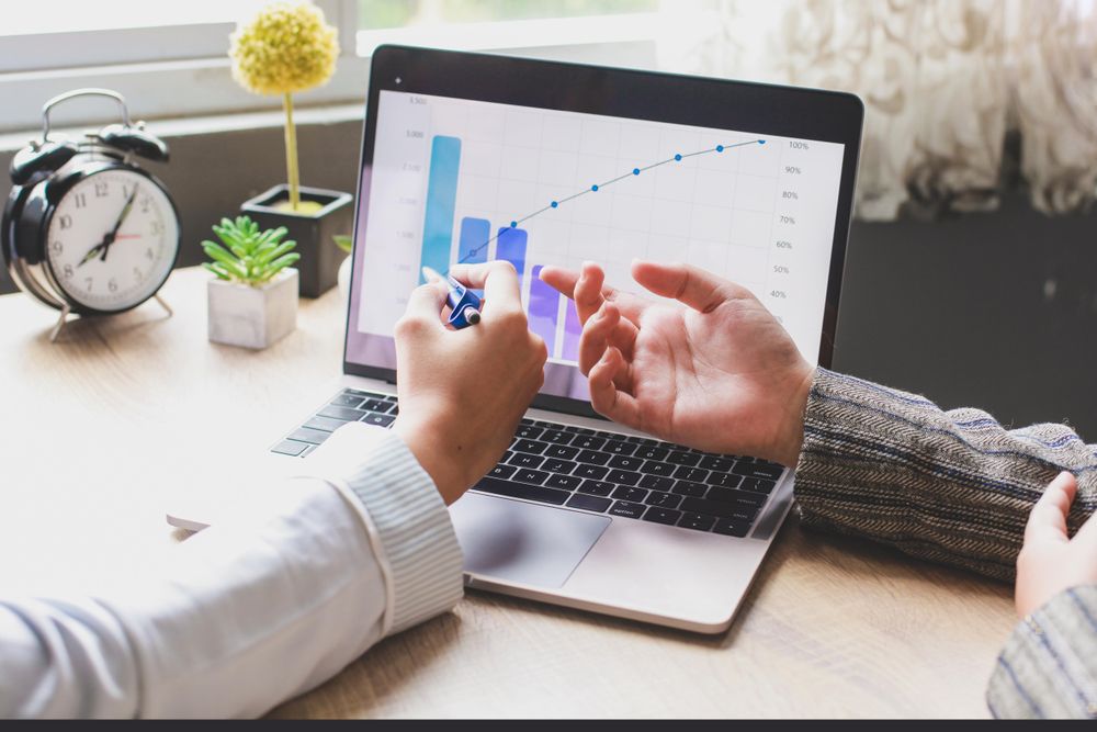 Two people discussing  statistics on business in an office