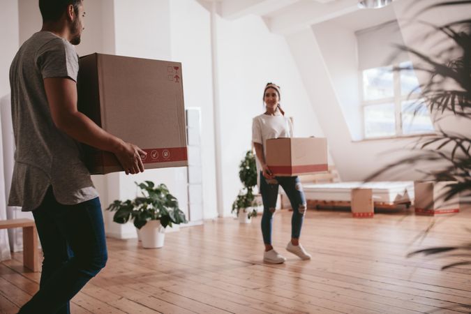 Man and woman unpacking boxes into new living space
