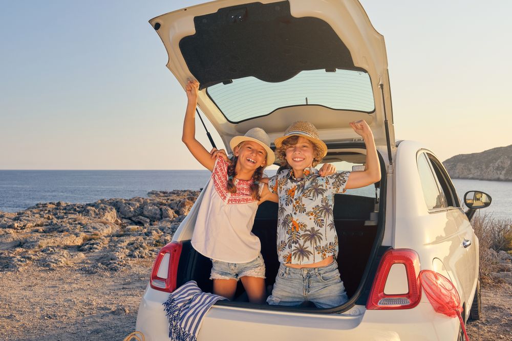 Kids inside the trunk of the car making a gesture of victory