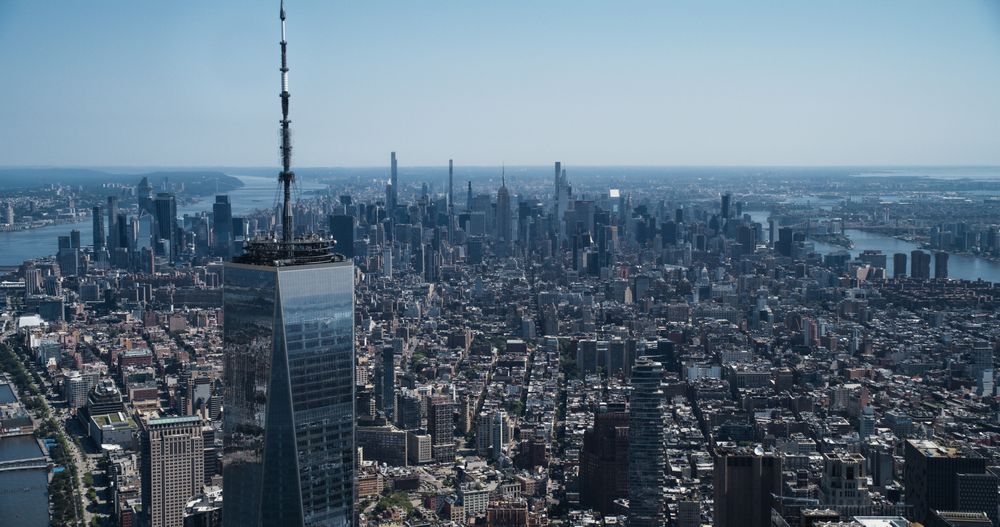 Aerial Photo with Top of the One World Trade Center Skyscraper with Antenna. Helicopter Flying Around the Glass Building with a View on Greater New York City Boroughs