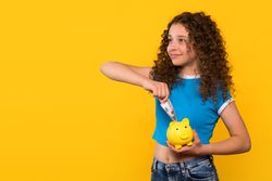 Girl putting money into piggy bank