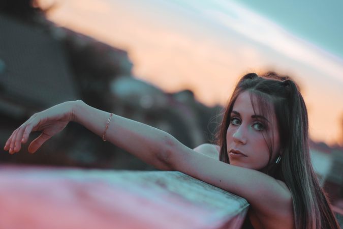 Portrait of young woman leaning on high balustrade outdoor