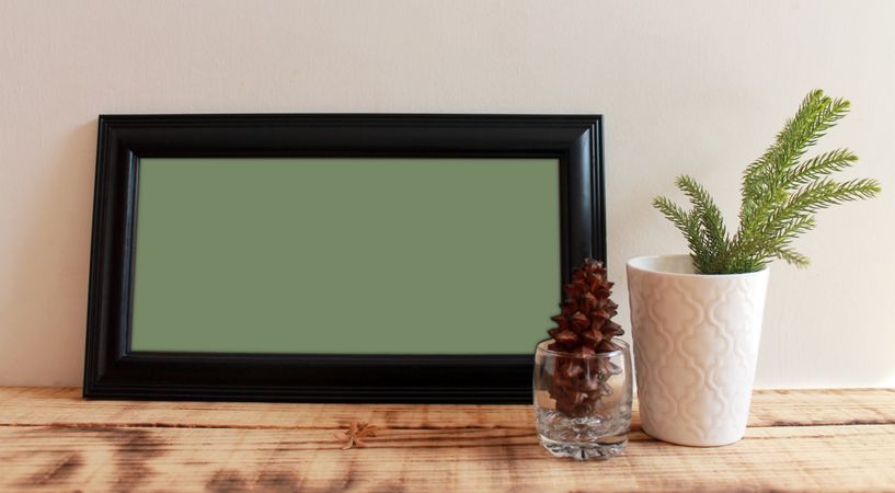 Rectangular long picture frame with green interior mockup with branch and pinecone