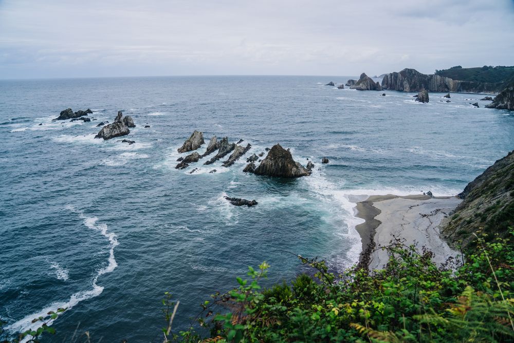 Rocky peaks surrounded by foamy water in windy day