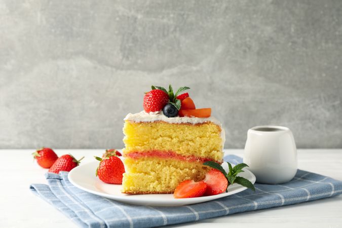 Composition with delicious berry cream cake against gray background. Tasty dessert