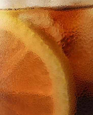 Side view background of cold cola with ice in glass, closeup