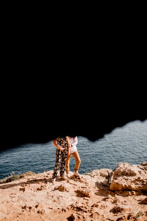 Couple embracing on rock
