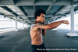 Black male athlete doing boxing training in underpass 0vrmp0