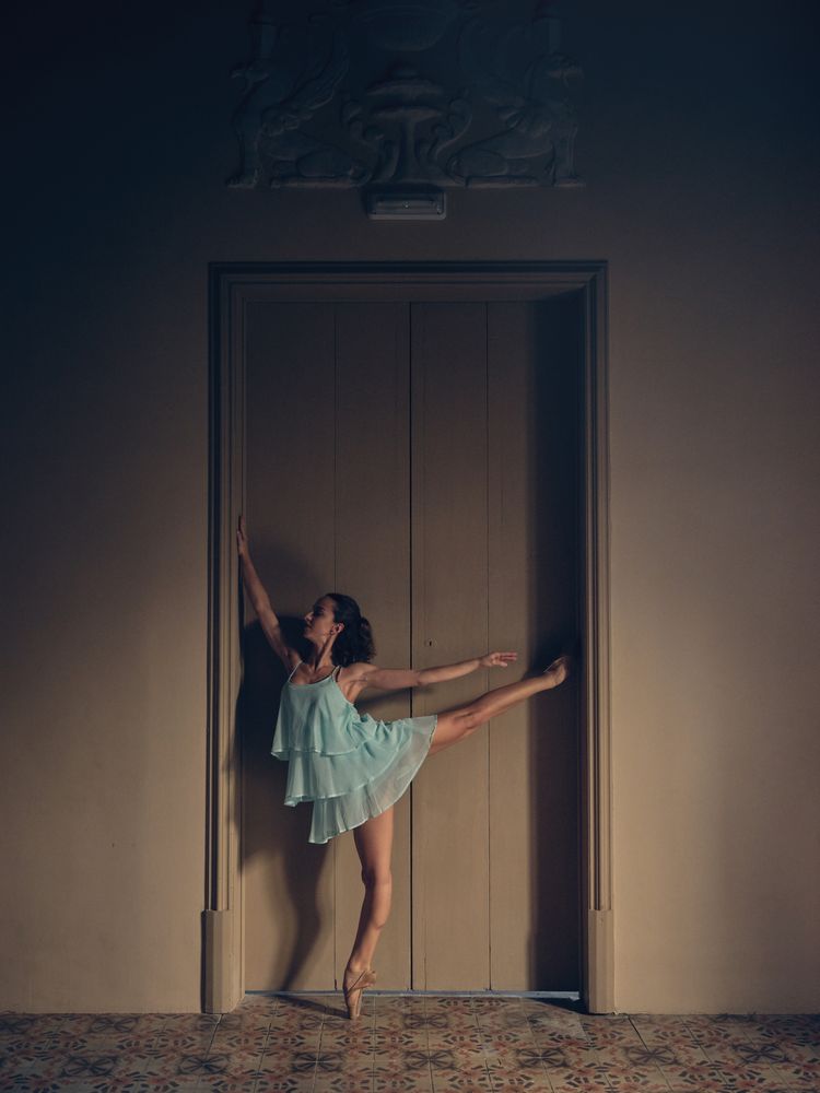 Ballerina standing near room door
