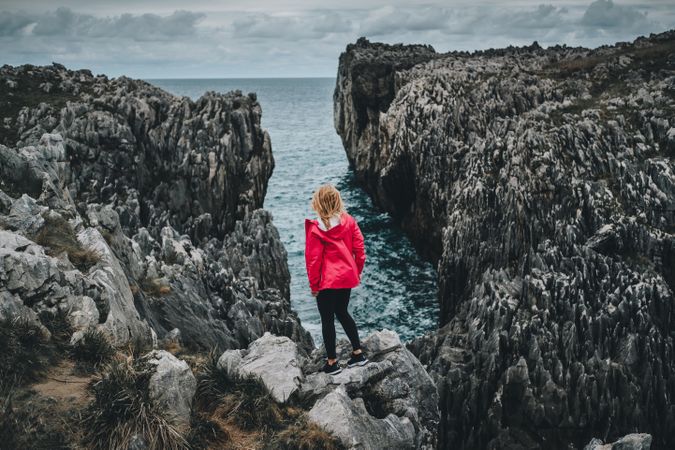 Female standing on cliff and contemplating