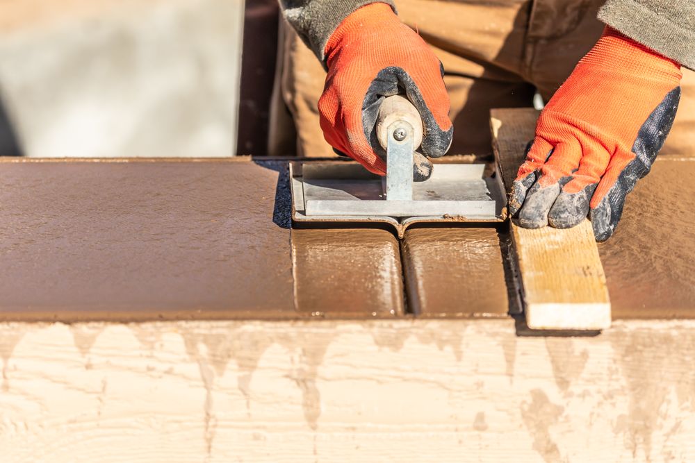 Construction Worker Using Hand Groover On Wet Cement Forming Coping Around New Pool